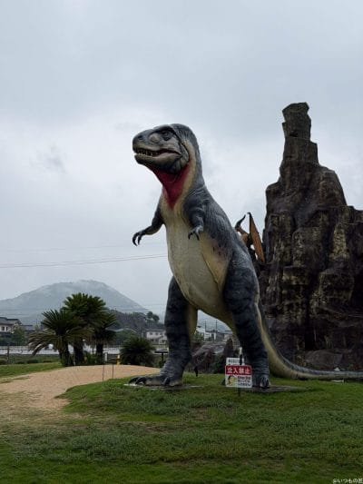 曇り空の下に立つティラノサウルスのオブジェ | iphone review.jp iPhone 17 Pro カメラ 曇り空の下に立つティラノサウルスのオブジェ