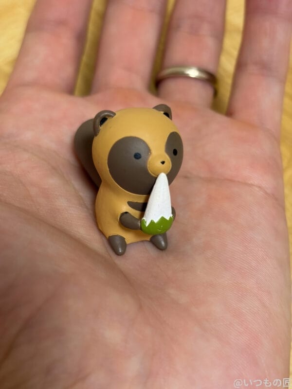 iPhone Air カメラ 手のひらの上のちいさな狸のマスコット人形